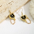 Boucles d'oreilles cœur gothiques dorées avec croix en relief et chaînes sur fond de pierre - Or