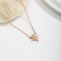 Close-up of rose gold starburst pendant necklace with sparkling center zircon crystal - Starburst/Sunburst Style (XE481-1) / Rose Gold