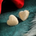 Elegante beige pluche hart oorknopjes met gouden rand op donkergroene achtergrond - Beige Pluche Stijl