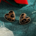 Vista macro di orecchini a forma di cuore con stampa leopardata e base dorata - Stile Leopardato Opaco