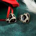 Dettaglio di orecchini a cuore con stampa leopardata e bordo in metallo dorato lucido - Stile Leopardato Lucido