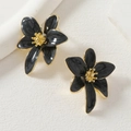Detalle de los pendientes de flores en esmalte negro jaspeado con acabados metálicos dorados - Negro
