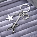 Detailed close-up of a silver electric guitar keychain with star charm and heart clasp - Black