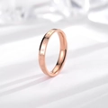 Minimalist rose gold titanium ring with BE THE CHANGE engraving on white background - Rose Gold