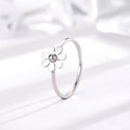 Macro dettaglio di un anello a margherita minimalista con petali d'argento su sfondo bianco - US 4 / Margherita / Argento