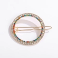 Dettaglio di un fermaglio rotondo dorato con strass multicolore in un design circolare - Stile Tondo Oro con Strass Colorati (NXF00049)