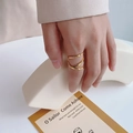 Minimalist 18k gold geometric multilayer wrap ring worn on a finger in a soft setting - US 6 / Gold