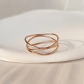 Close-up of layered rose gold titanium steel ring with minimalist intertwined line design - US 5 / Rose Gold