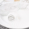 Macro shot of multi-layer wrap silver titanium steel ring on an elegant porcelain tray - US 5 / Silver