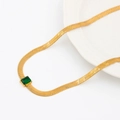 Collier maille serpent dorée avec pendentif en zircon vert rectangulaire sur fond blanc - Émeraude