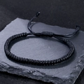 Handmade black Tibetan knot rope bracelet for men and women on a dark stone background - Vajra Knot Braided Rope (B3405)