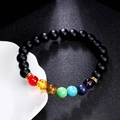 Detail eines 8mm Chakra-Armbands mit Tigeraugen-Steinen auf weißer Keramikschale - Matter Stein