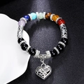 Makro-Detail des Chakra-Lavastein-Armbands mit silbernem Herzanhänger und Hohlperlen - Mehrfarbig Herz Anhänger