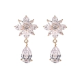 Detalle de pendientes de flor dorados con pétalos de circón y cristales de gota transparentes - Gota de Agua Floral Dorada (E1210)
