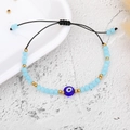 Detail view of woven evil eye bracelet with blue crystal beads and golden steel accents - Gold Bead Lake Blue Eye (B2123)