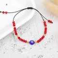 Detail of beaded bracelet with red crystal beads, gold spacers, and blue evil eye charm - Gold Bead Red Eye (B2125)