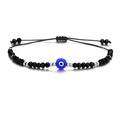 Macro shot of evil eye bracelet with black faceted beads and adjustable woven cord - Steel Bead Black Eye (B2130)