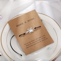 Dettaglio del bracciale a tartaruga nera su un biglietto d'auguri in un piatto bianco - Tartaruga Argentata (B2513)