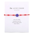Detalle de pulsera de cuerda roja tejida con cuenta de ojo turco sobre tarjeta - Cordón Rojo (B2140)