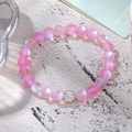 Macro detail of pink frosted mermaid bead bracelet with a crystal pave metal centerpiece - Pink