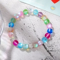 Detailed macro view of colorful frosted beads bracelet with a pavé crystal ball charm - Colorful