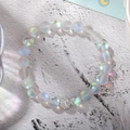 Macro view of frosted aurora beads with a sparkling rhinestone-paved metal accent ball - White