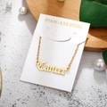 Macro detail of a gold stainless steel Cancer zodiac pendant necklace on a natural display - Cancer-Gold