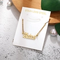Detail of Aries gold stainless steel necklace on white card with decorative background - Aries-Gold
