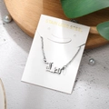 Detailed close-up of Leo zodiac pendant necklace in stainless steel on display card - Leo-Silver