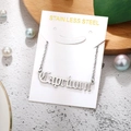 Macro shot of silver stainless steel Capricorn pendant necklace on white card - Capricorn-Silver
