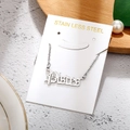 Macro shot of silver stainless steel Pisces zodiac pendant on elegant display card - Pisces-Silver