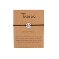 Handmade Taurus zodiac bracelet with black woven rope and golden metal pendant on a card - Silver Taurus (B0811)