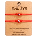 Detail of two handmade red string Evil Eye bracelets on a brown paper card - Red Bead Red Cord (B2934)