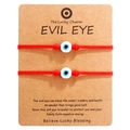 Detailed view of two red woven Evil Eye bracelets on a brown paper card with description - Blue Bead Red Cord (B2935)