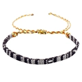 Detail van een bohemien geweven armband met geometrische patronen en kleurrijke koorden - Zwart & Wit Geometrisch (B2956)