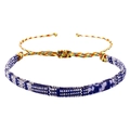 Detailopname van een handgemaakte gevlochten vriendschapsarmband met schuifknoopsluiting - Blauw Wit Paars Platte Band (B2963)