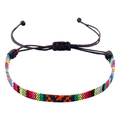 Macro-opname van kleurrijke boho gevlochten armband met verstelbaar zwart waxkoordje - Zwart Koord Rood Geel Groen