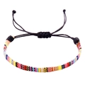 Detail van een handgemaakte kleurrijke Boheemse gevlochten armband met schuifknoop - Zwart Koord Geel Blauw Rood