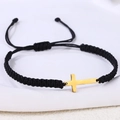 Nahaufnahme von handgeflochtenem schwarzem Armband mit goldenem Kreuz aus Edelstahl - Edelstahl Gold Kreuz (B3427)