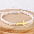 Detail eines handgewebten weißen Armbands mit einem minimalistischen goldenen Kreuz - Edelstahl Gold Kreuz (B3428)