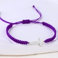 Detail eines lila gewebten Armbands mit poliertem Silberkreuz und verstellbarem Knoten - Edelstahl Silber Kreuz (B3429)