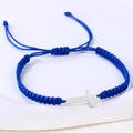 Detail eines handgewebten tiefblauen Seilarmbands mit einem polierten silbernen Metallkreuz - Edelstahl Silber Kreuz (B3433)