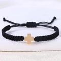 Detail van handgeweven zwarte armband met gepolijst gouden roestvrijstalen kruishanger - Hematiet Kruis (B3443)
