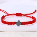 Detail eines roten handgeflochtenen Seilarmbands mit mattgrauem Edelstahl Kreuzanhänger - Hämatit Kreuz (B3448)