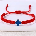 Detail eines roten handgewebten Seilarmbands mit blauem Kreuzanhänger und Schiebeknoten - Hämatit Kreuz (B3450)