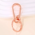 Dettaglio macro del portachiavi in metallo oro rosa con moschettone a molla e anello - 7x3cm / Oro rosa