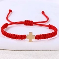 Detail van een rode geweven armband met gouden roestvrijstalen kruis en schuifsluiting - Hematiet Kruis (B3452)