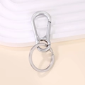 Portachiavi in metallo argento lucido con moschettone e anello su piedistallo bianco minimale - 7x3cm / Argento