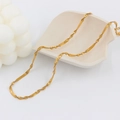 Macro shot of gold-plated stainless steel wavy chain necklace with fine metal texture - Twisted Snake Chain Necklace / Gold