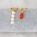 Detail of asymmetric gold earrings with freshwater pearls and red teardrop zircon stones - Red